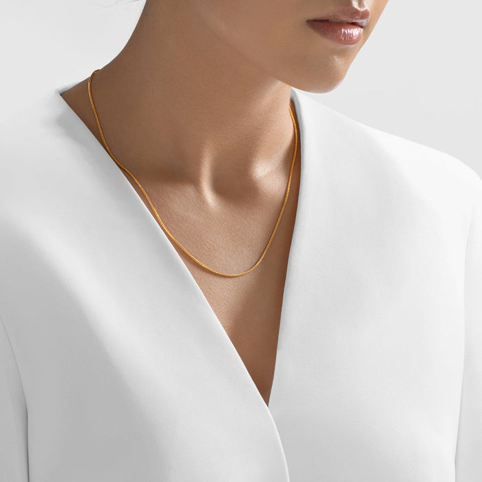 Gold chain necklace worn on model